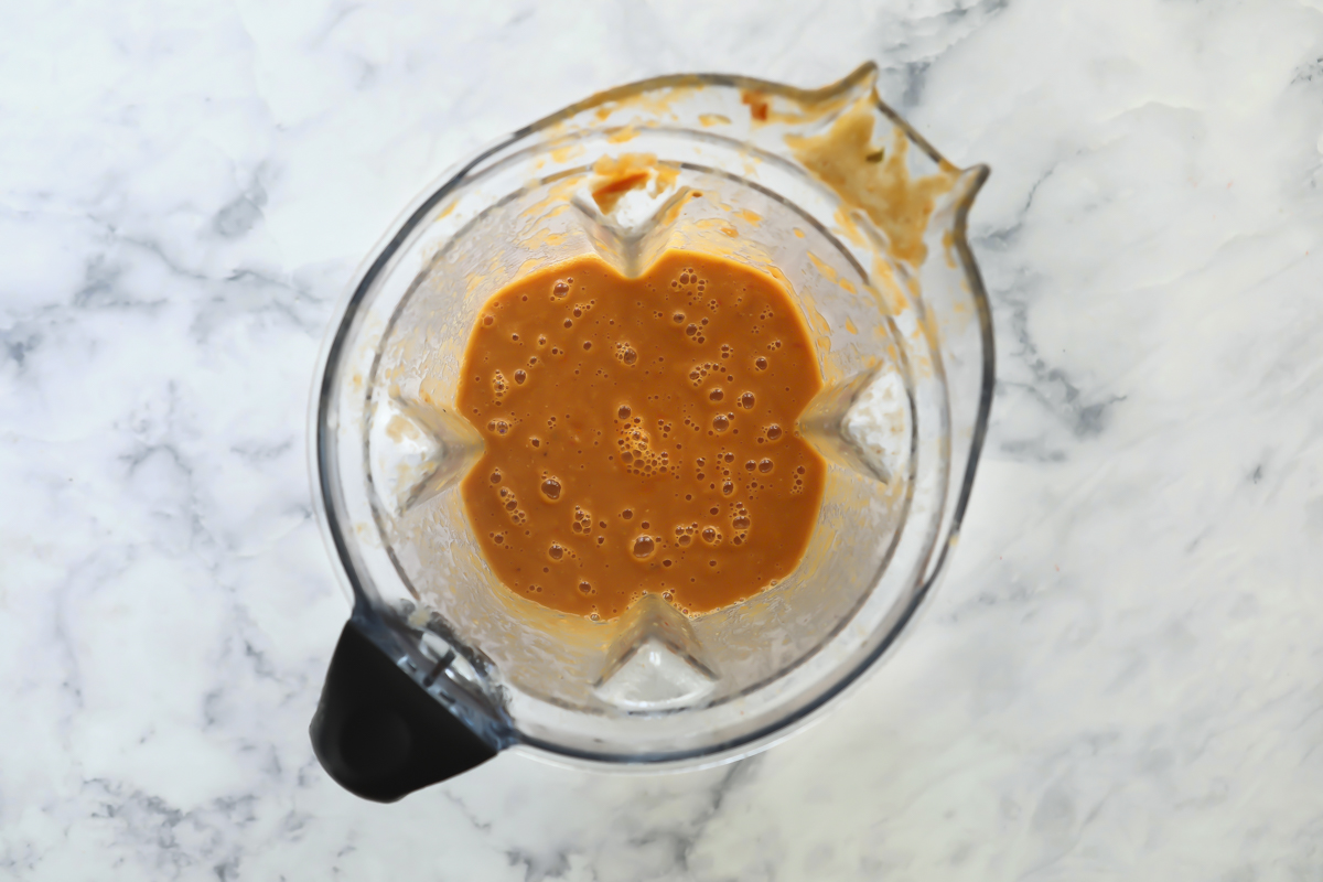 A blender with brown liquid in it.